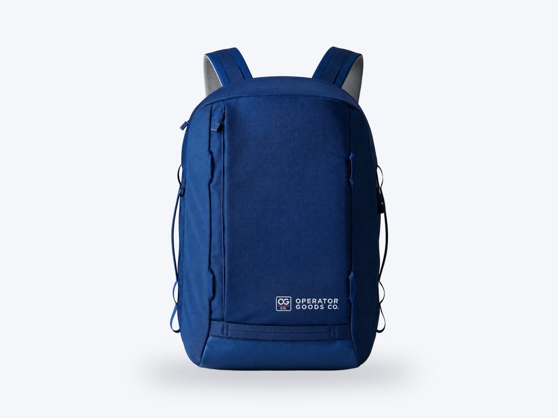 A navy YETI backpack with the Operator Goods Co. logo.